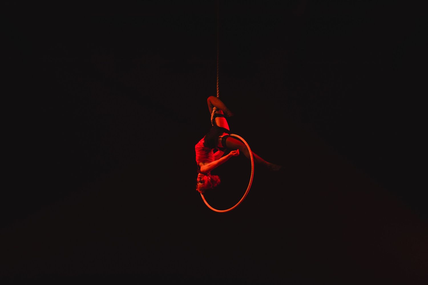 Abstract red circular light patterns against a dark background in a performance space.