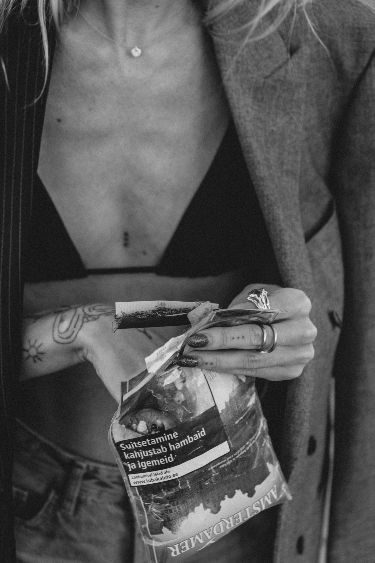 Close-up black and white shot of torso holding crumpled food packaging.