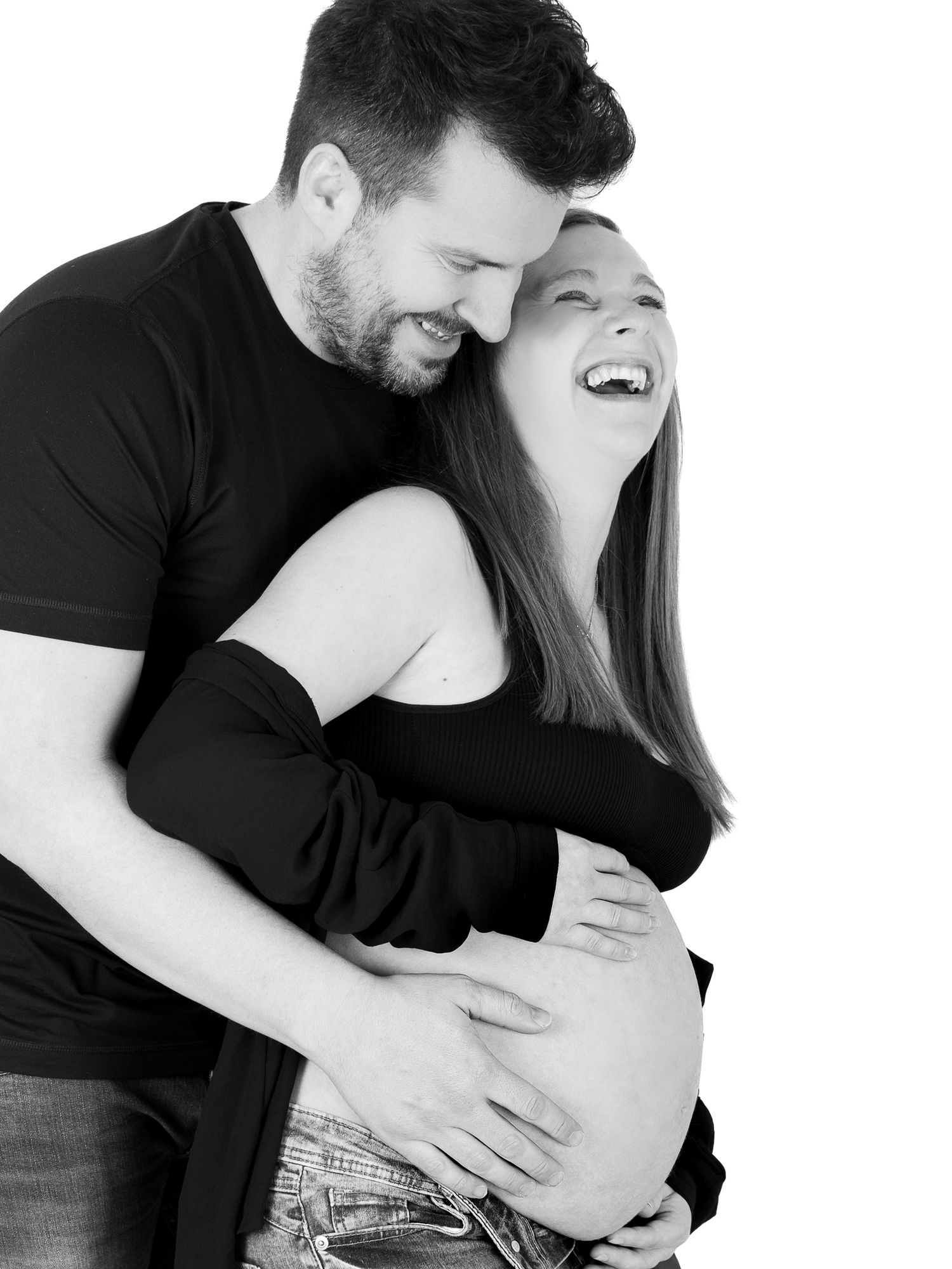Intimate black and white maternity photoshoot showing couple's tender moments.