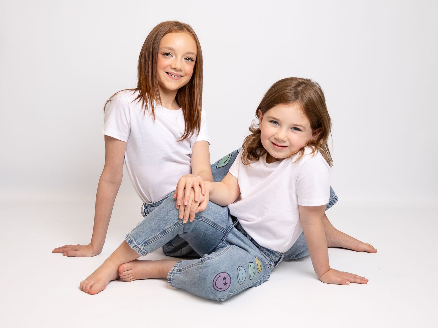 Family portrait session on white background showing relaxed casual poses.