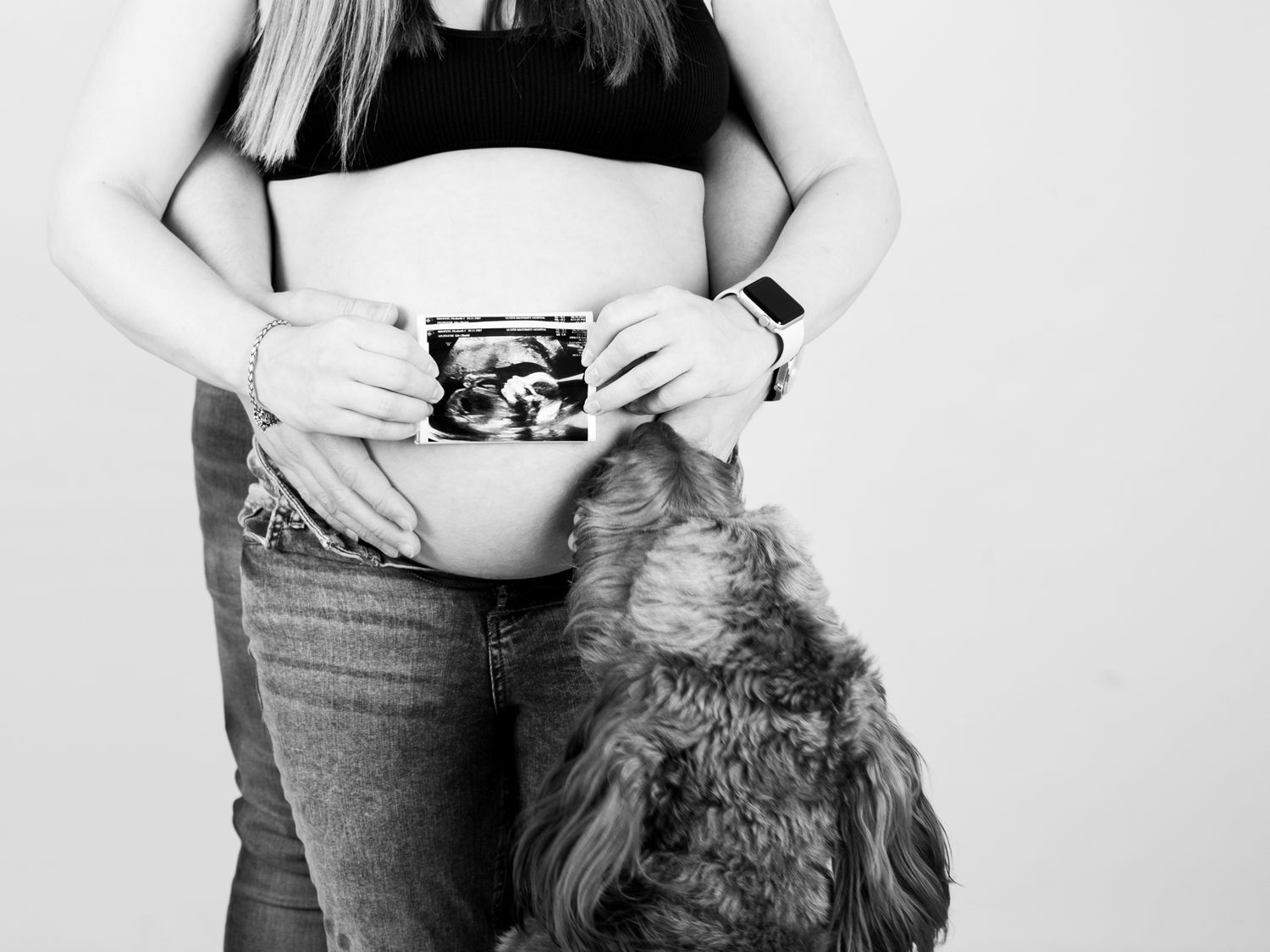 Black and white pregnancy announcement photoshoot showing ultrasound photos.
