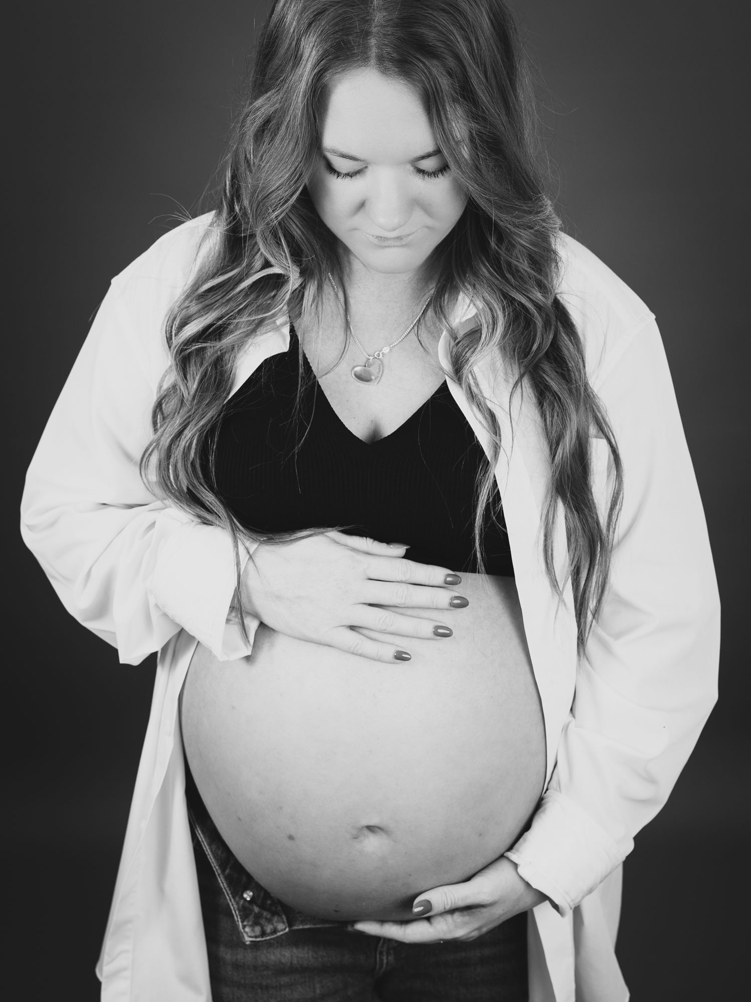 Intimate black and white maternity photography series with contrasting outfit elements.
