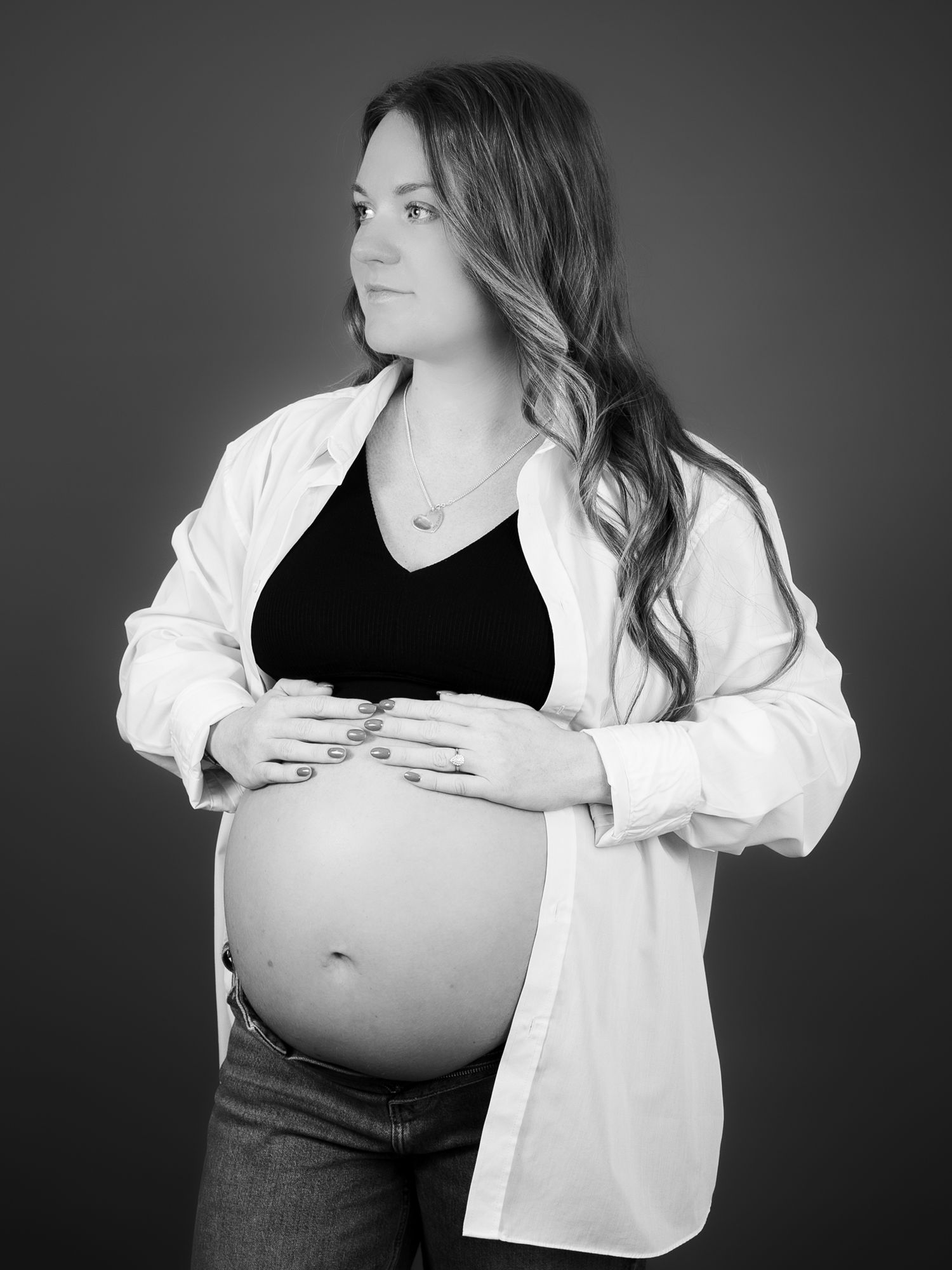 Dramatic black and white maternity portraits with white button-down shirt styling.