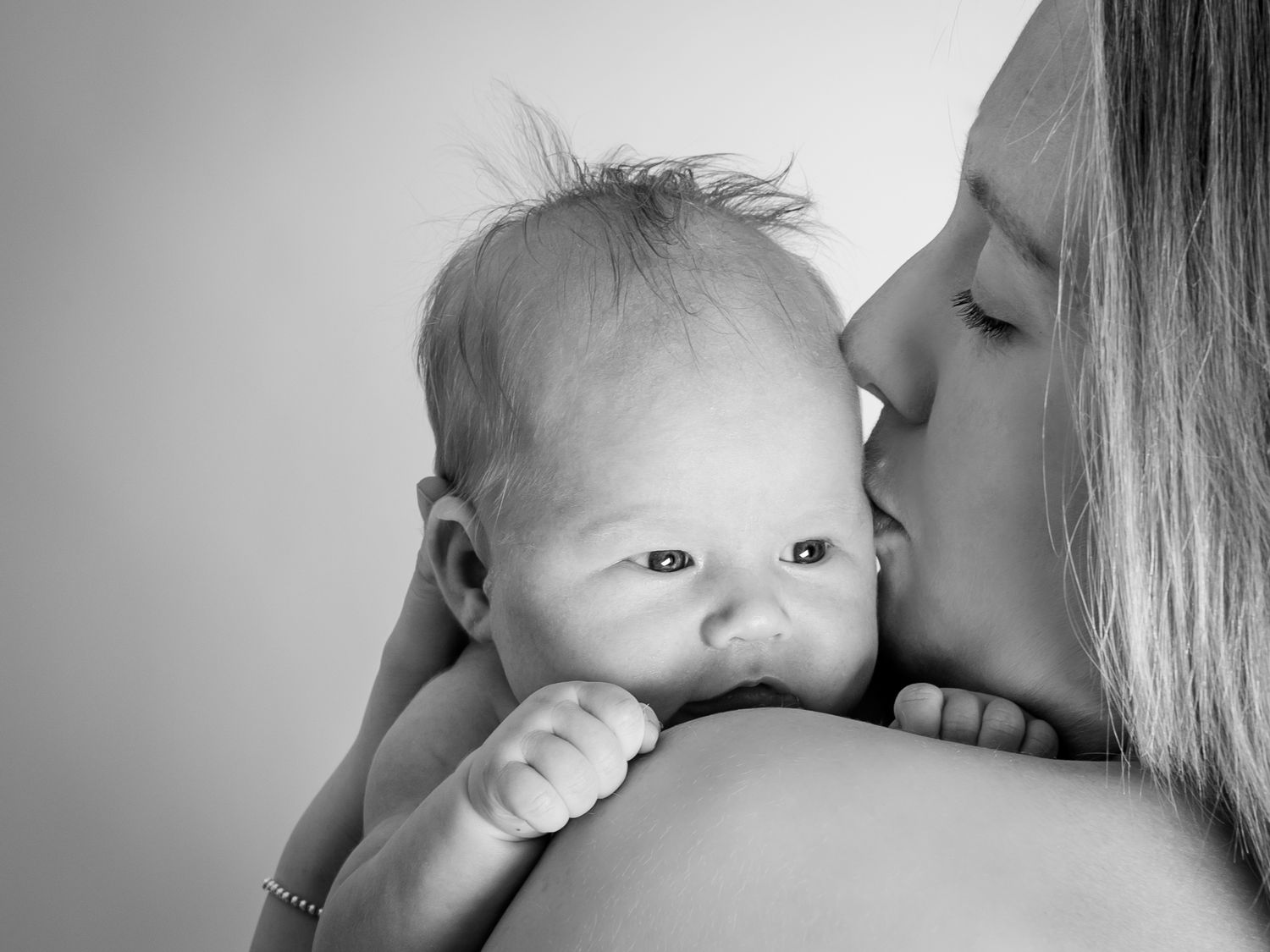Series of intimate black and white portraits showing tender family moments.