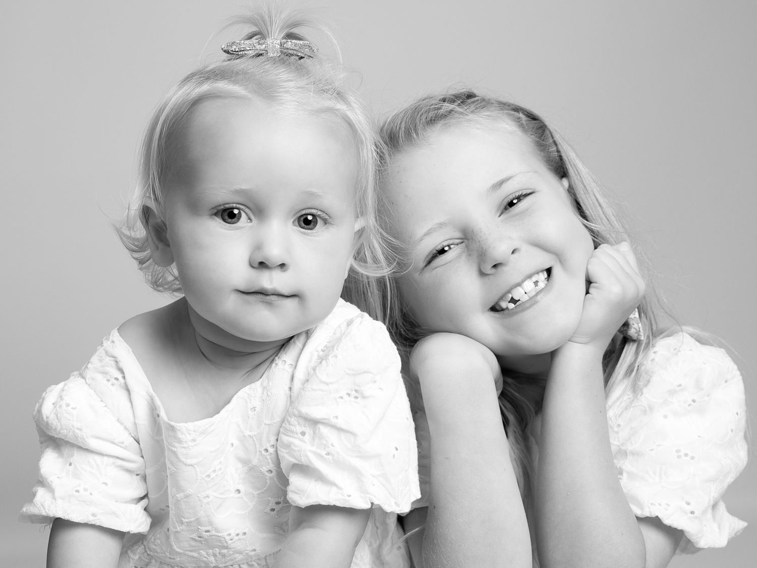 Sweet portrait series of toddlers in white clothing against light background.