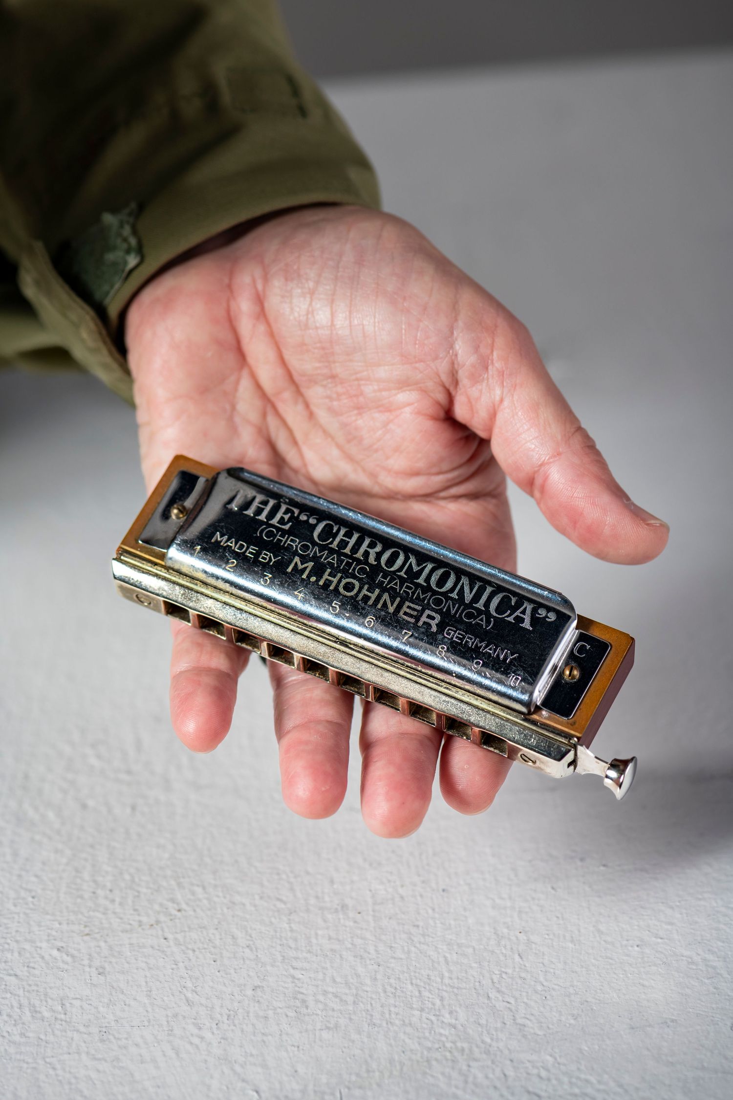 A series of close-up shots showing hands holding and demonstrating a Chromonica harmonica instrument.