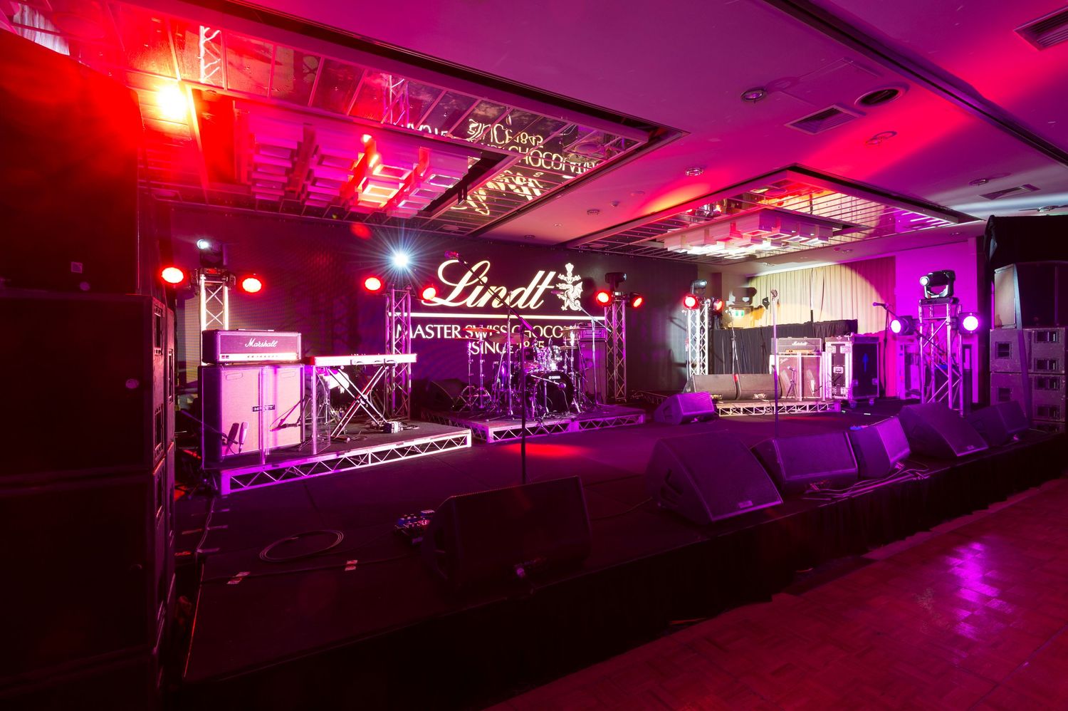 A nightclub interior illuminated with vibrant purple and red lighting creating a moody atmospheric ambiance.