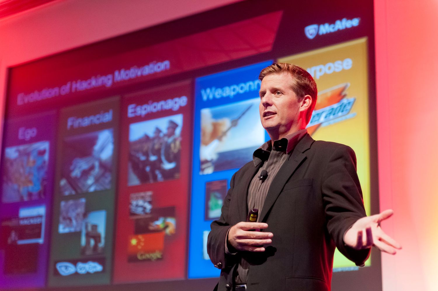 Conference presentation stage with colorful digital displays showing cybersecurity related content.