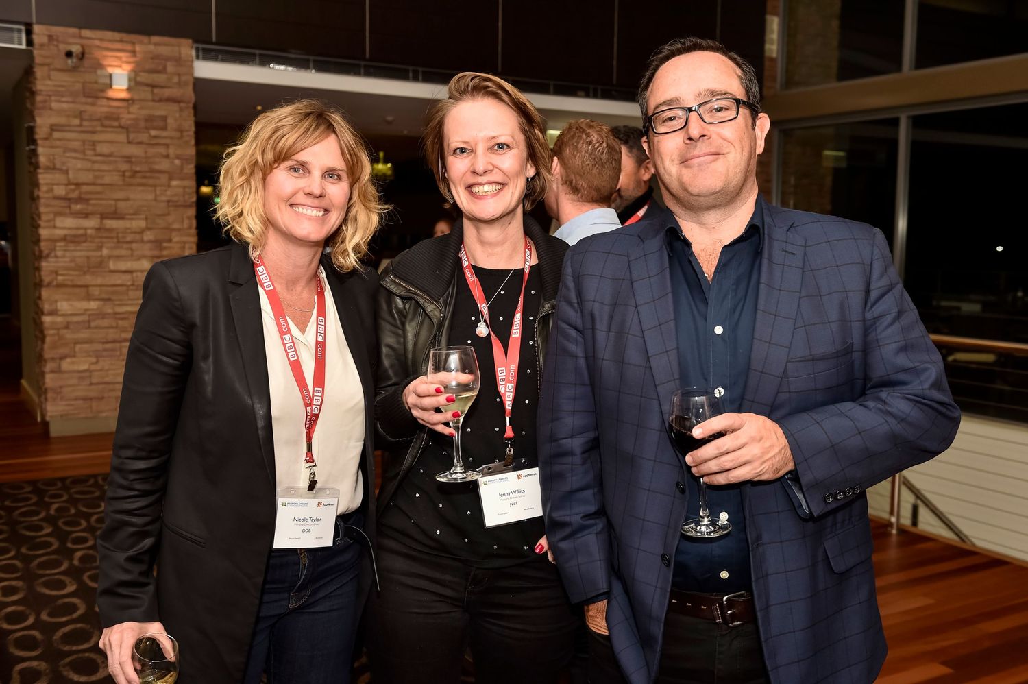 Corporate event attendees mingling and networking in a modern venue with mood lighting Rydges Resort Hunter Valley.