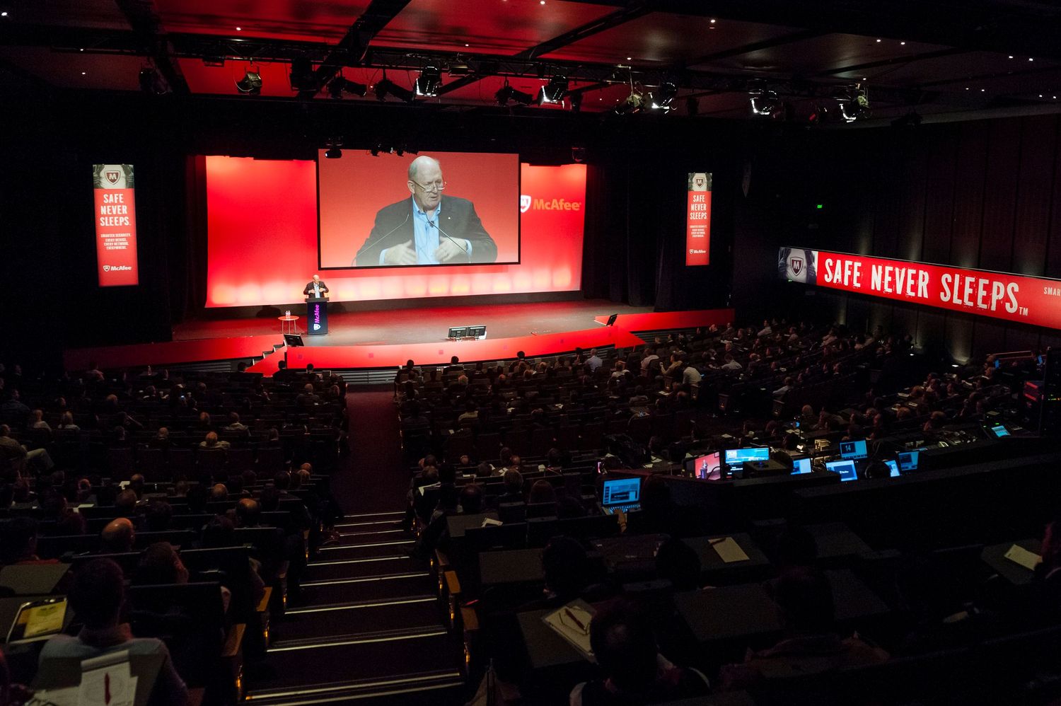 Panoramic view of Sydney ICC conference hall with red ambient lighting and large projection screens.
