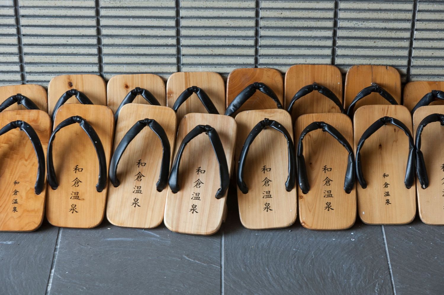 Row of wooden Japanese geta sandals arranged in sequential order.