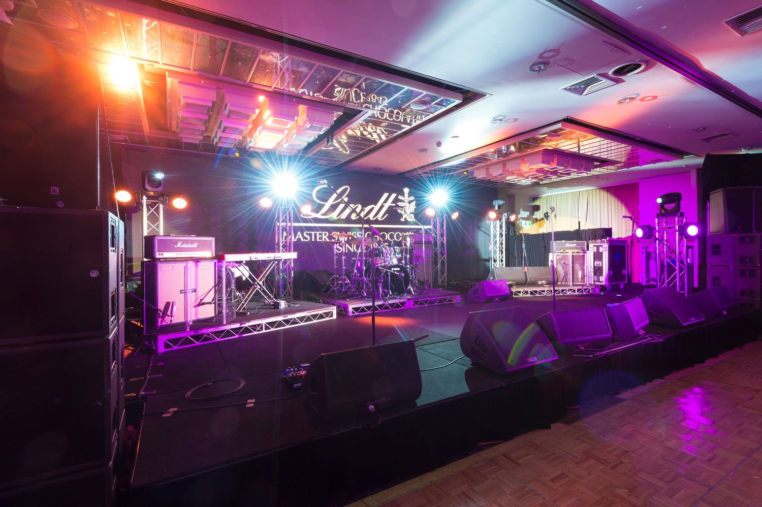 Nightclub interior with purple and orange lighting featuring Lindt branding and stage setup for an event.