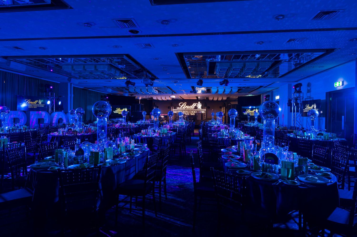 Nightclub interior with blue lighting illuminates dance floor and bar area showing modern entertainment venue setup.
