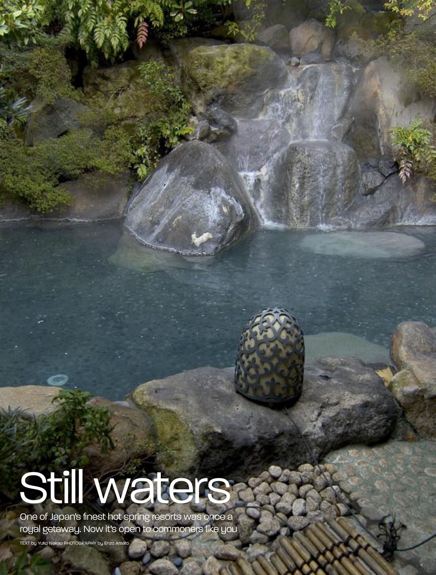 Scenic panorama of a tranquil blue pool surrounded by rocky outcrops and lush vegetation.