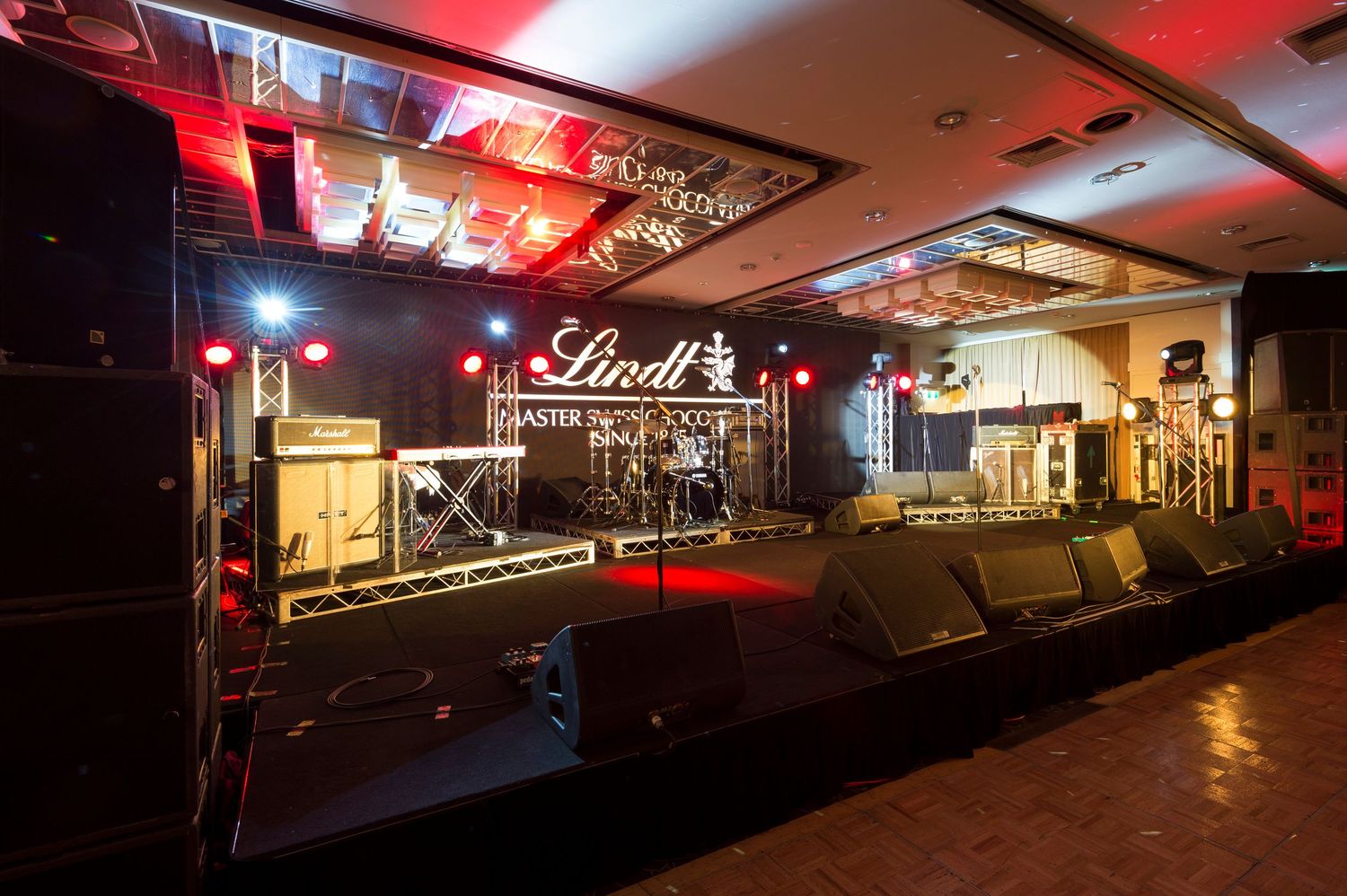 Dimly lit nightclub interior with red ambient lighting and neon signs creating a moody atmosphere.