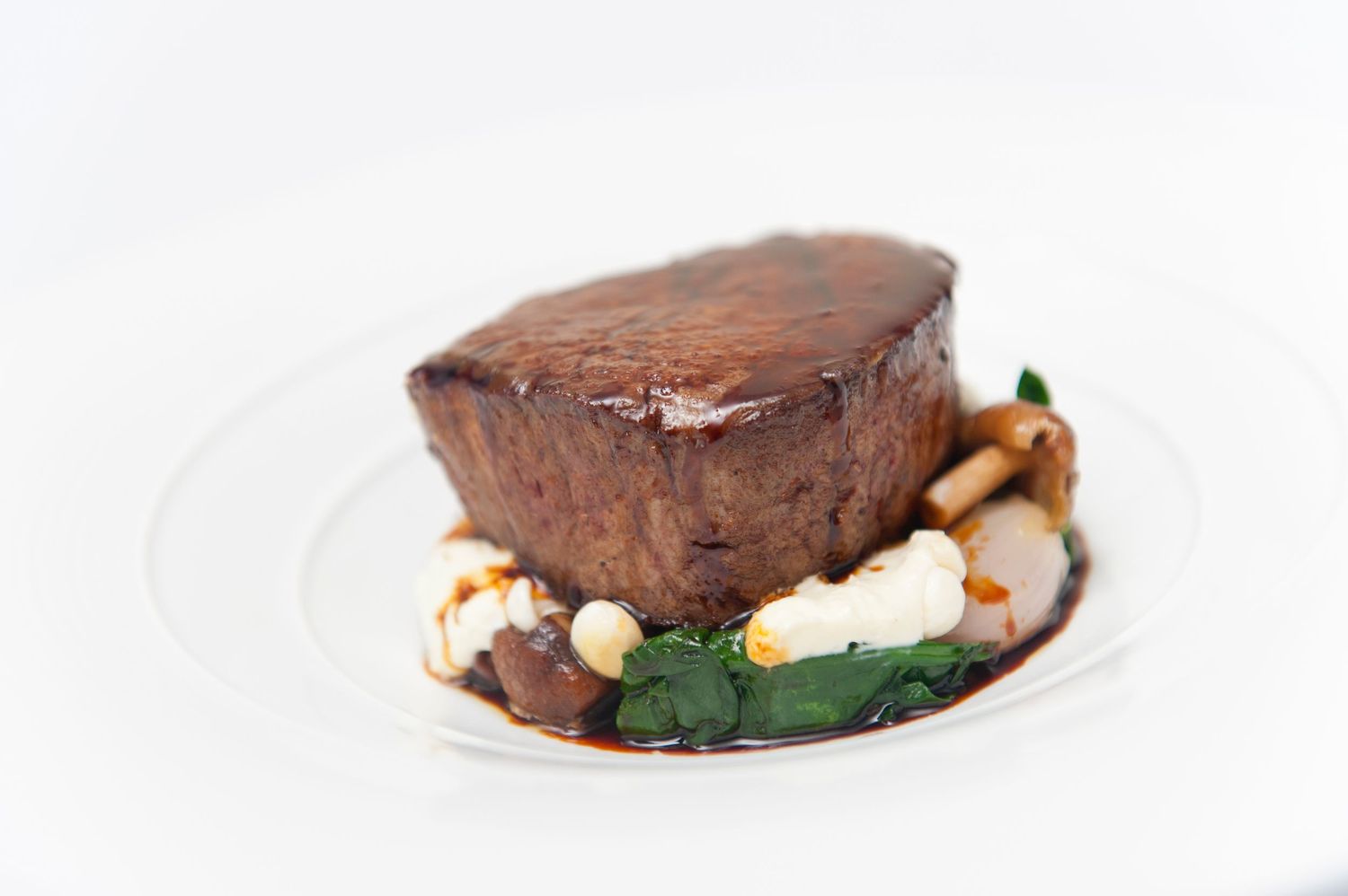 Chocolate dessert elegantly plated with delicate garnishes on white porcelain.