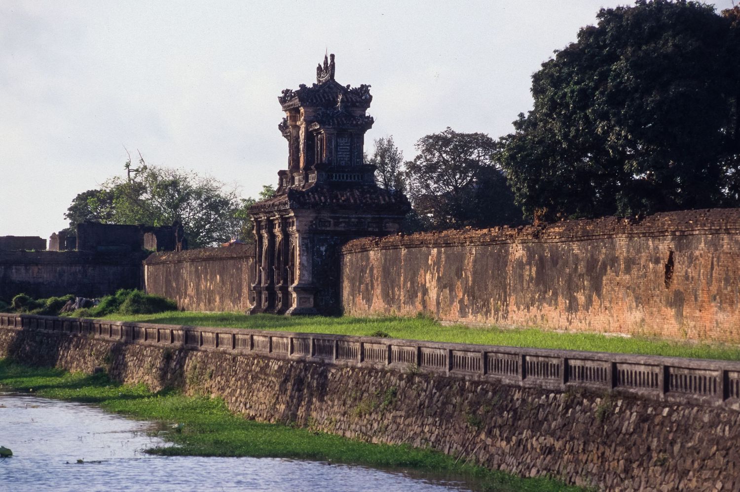 Ancient stone fortress wall stretching along a waterfront with historic architecture.