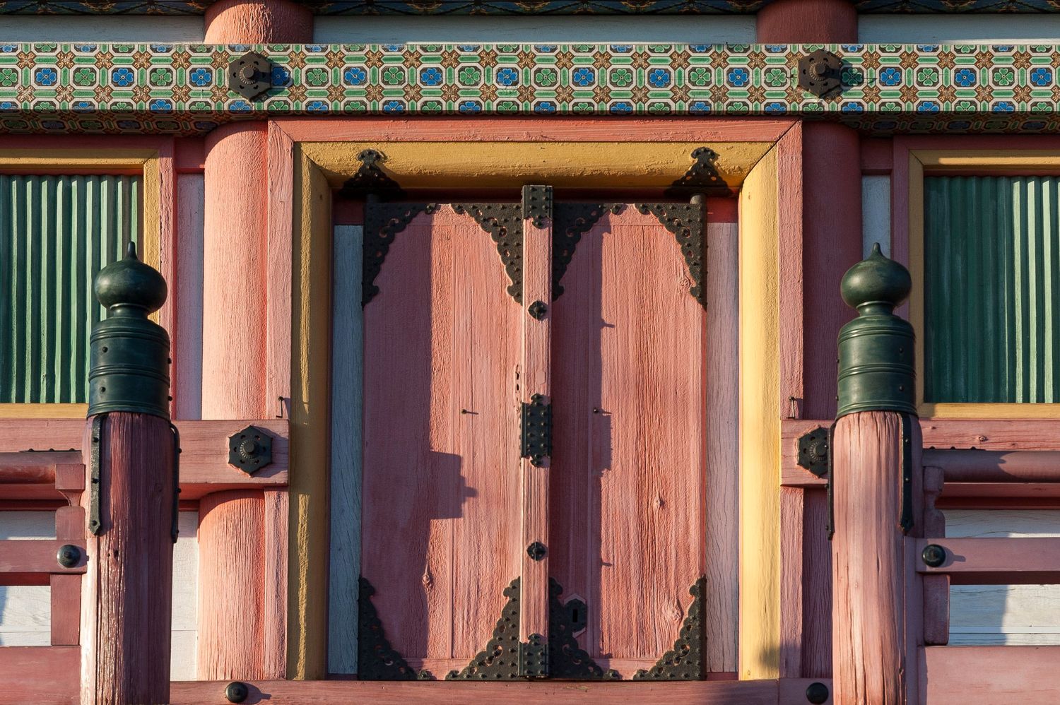 Colorful architectural detail of a Korean palace building with painted wooden beams and geometric patterns.