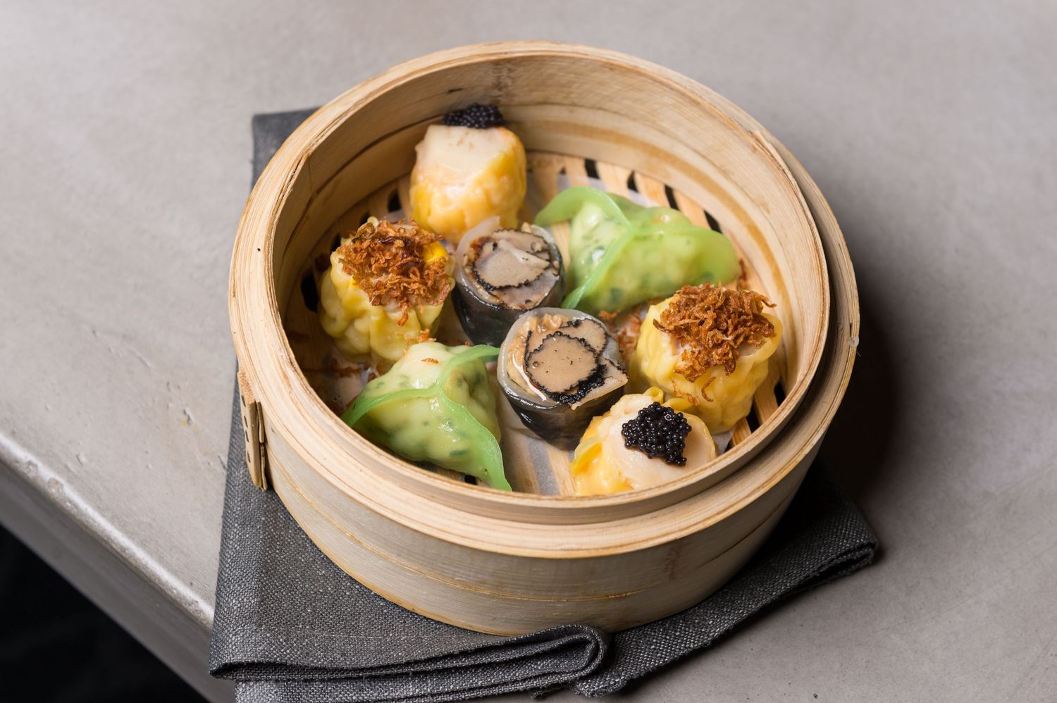 Steamed dumplings presented in traditional bamboo baskets with delicate garnishes.