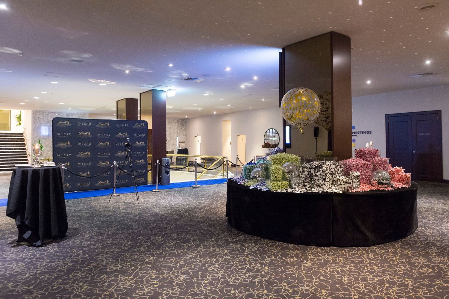 A panoramic view of a modern conference room with dark carpeting and ambient lighting shows multiple seating areas.