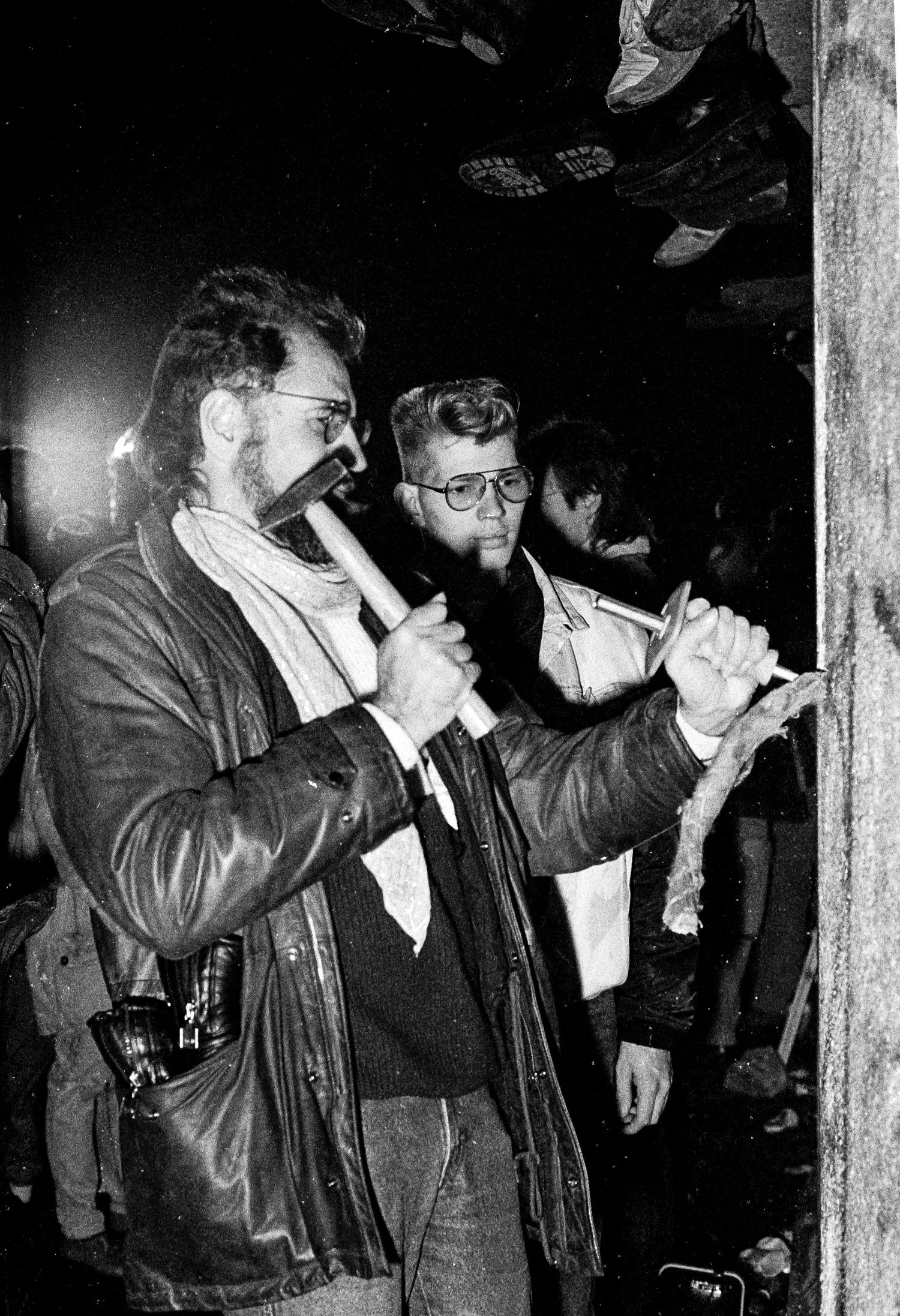 Group of photographers with cameras documenting events at the Berlin Wall.