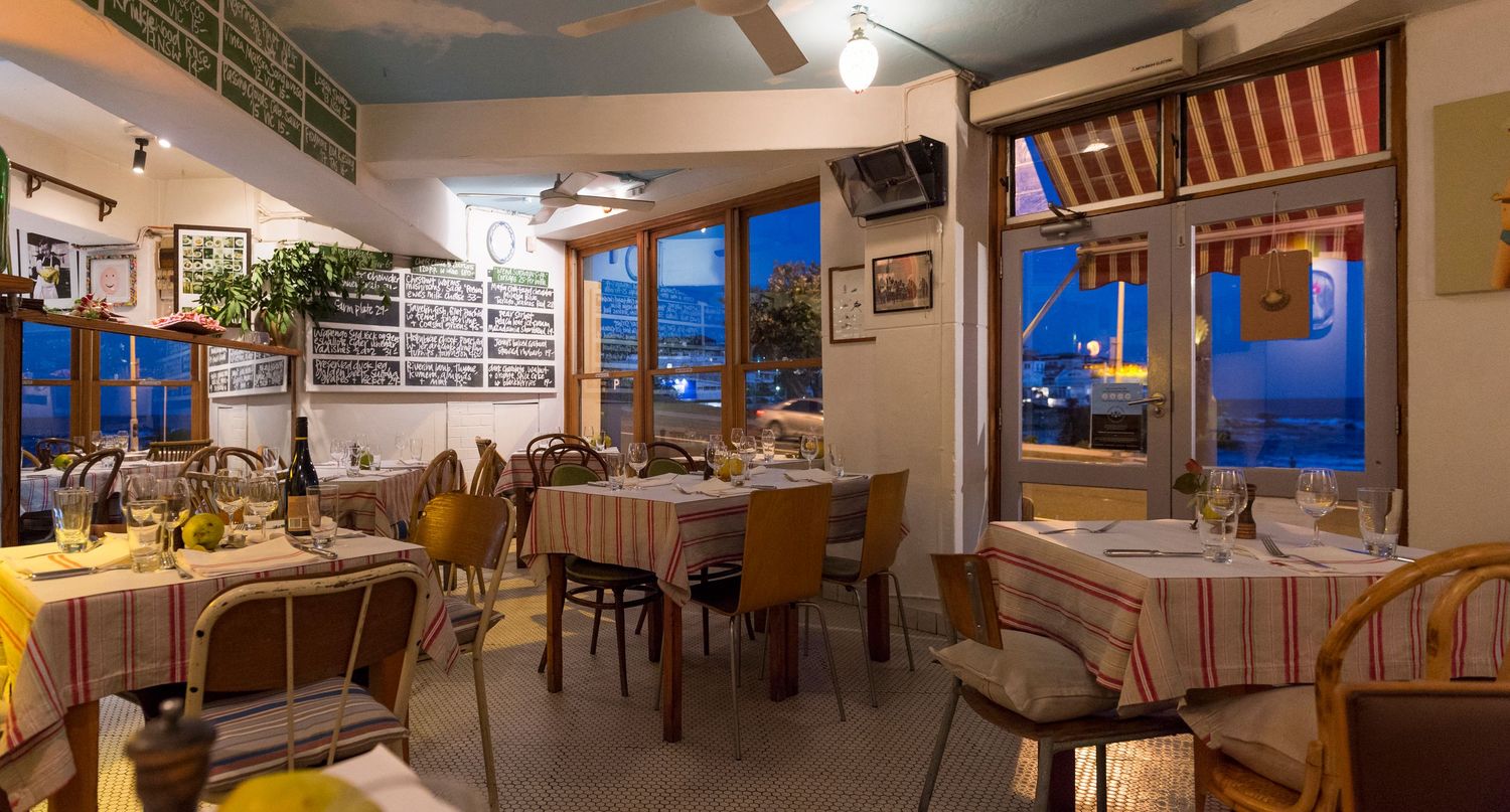 Panoramic view of a cozy restaurant dining room with warm lighting and rustic decor.