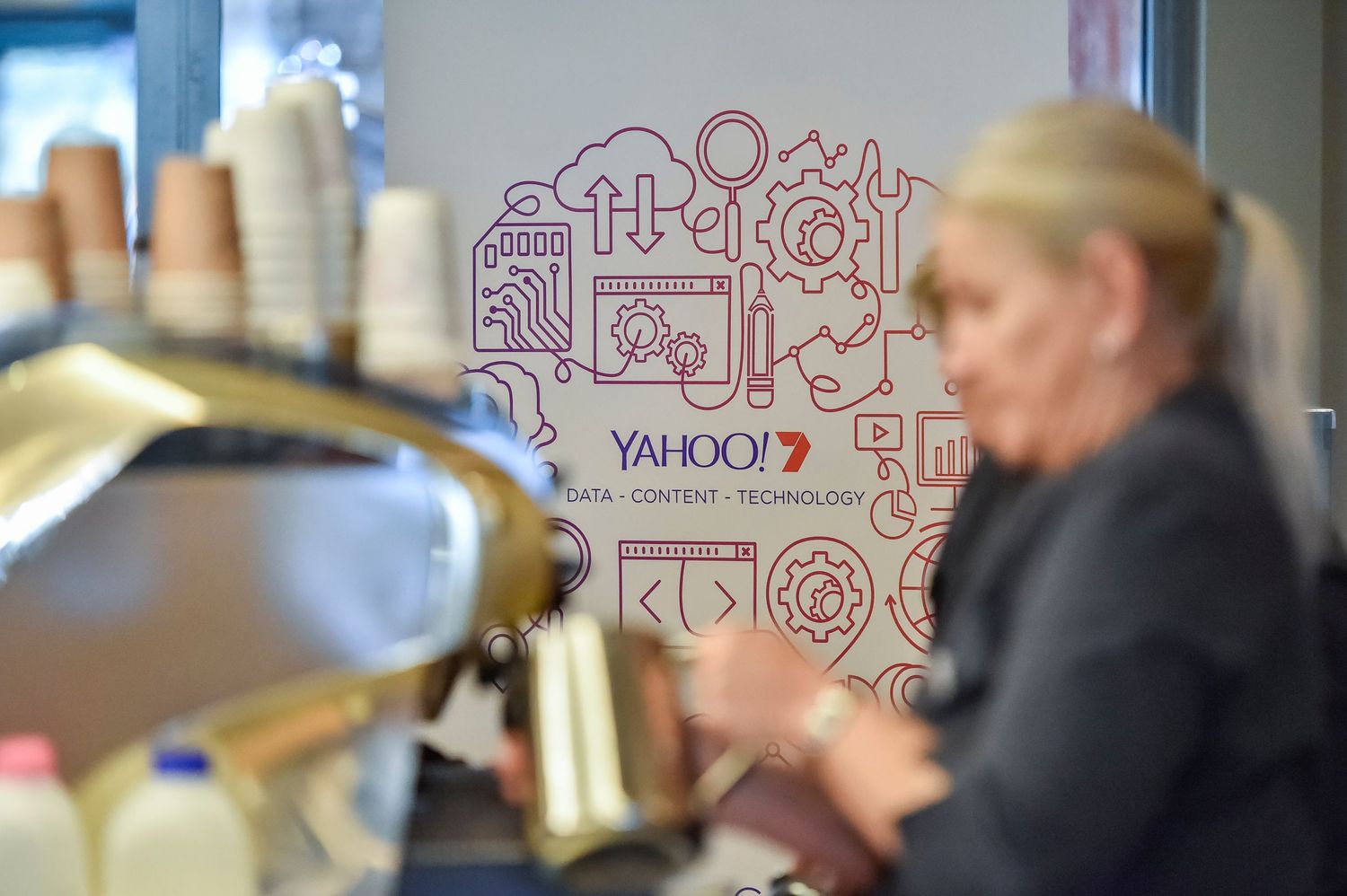Sponsored coffee cart at conference presentation with technology-themed graphics and icon.