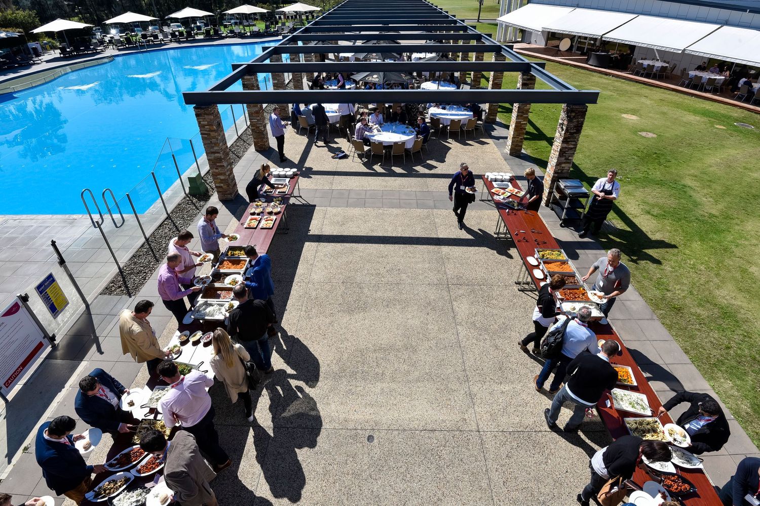 Outdoor event space with tables and umbrellas set up for conference attendees at Rydges Hotel & Resorts Hunter Valley.