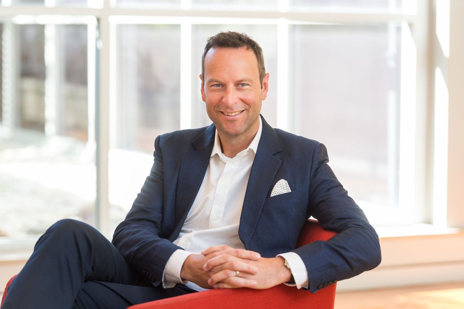 Business professional seated in modern office with natural lighting.