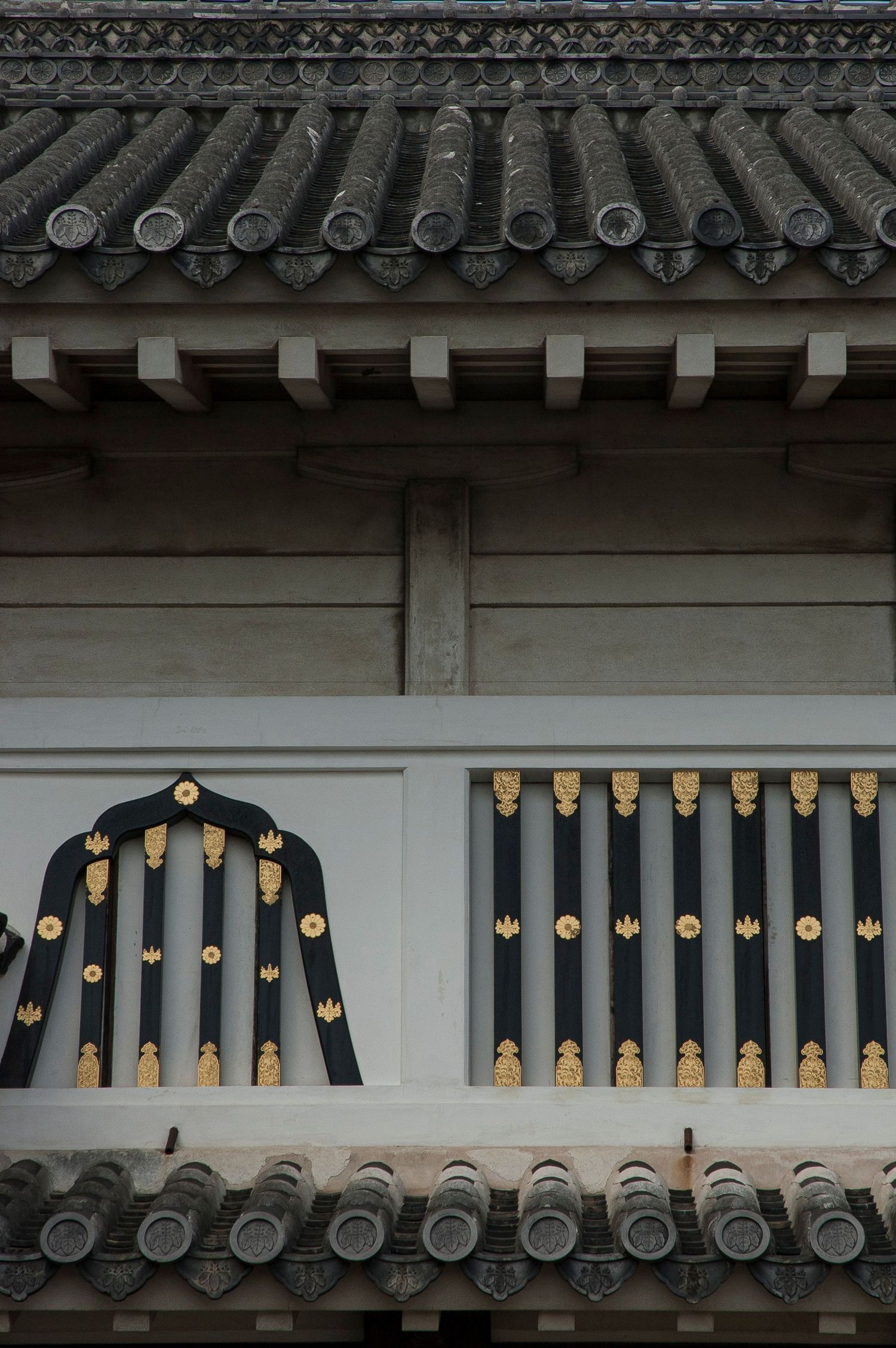 Traditional Japanese temple roof tiles with ornate black and gold decorative elements.