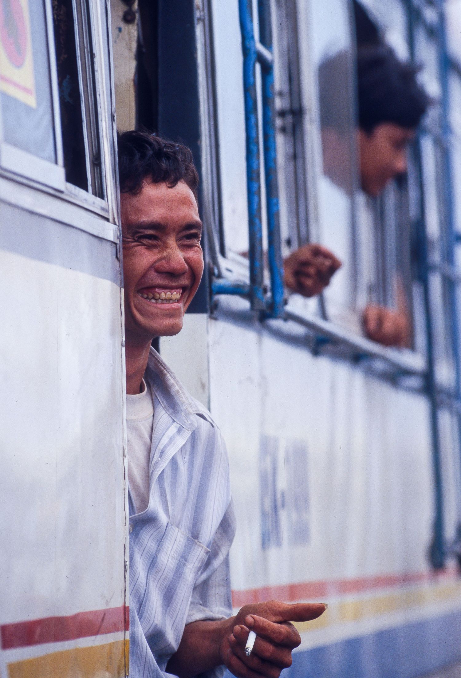 Passengers looking through windows of a moving train car.