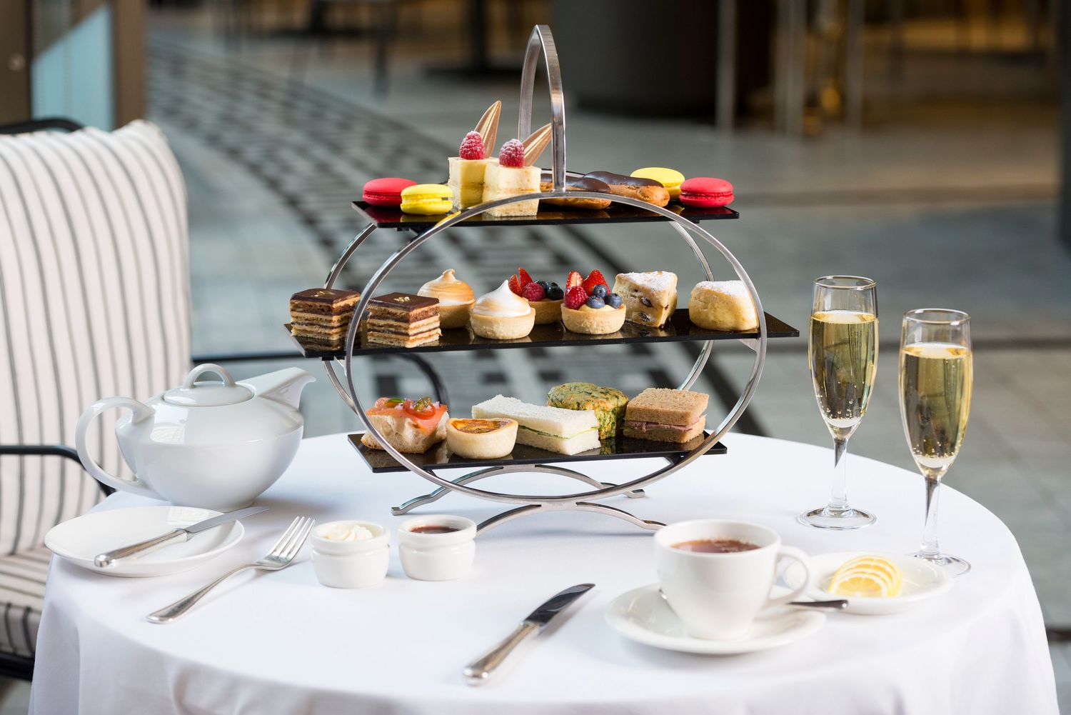 Elegant table setting with champagne glasses, pastries and afternoon tea service.