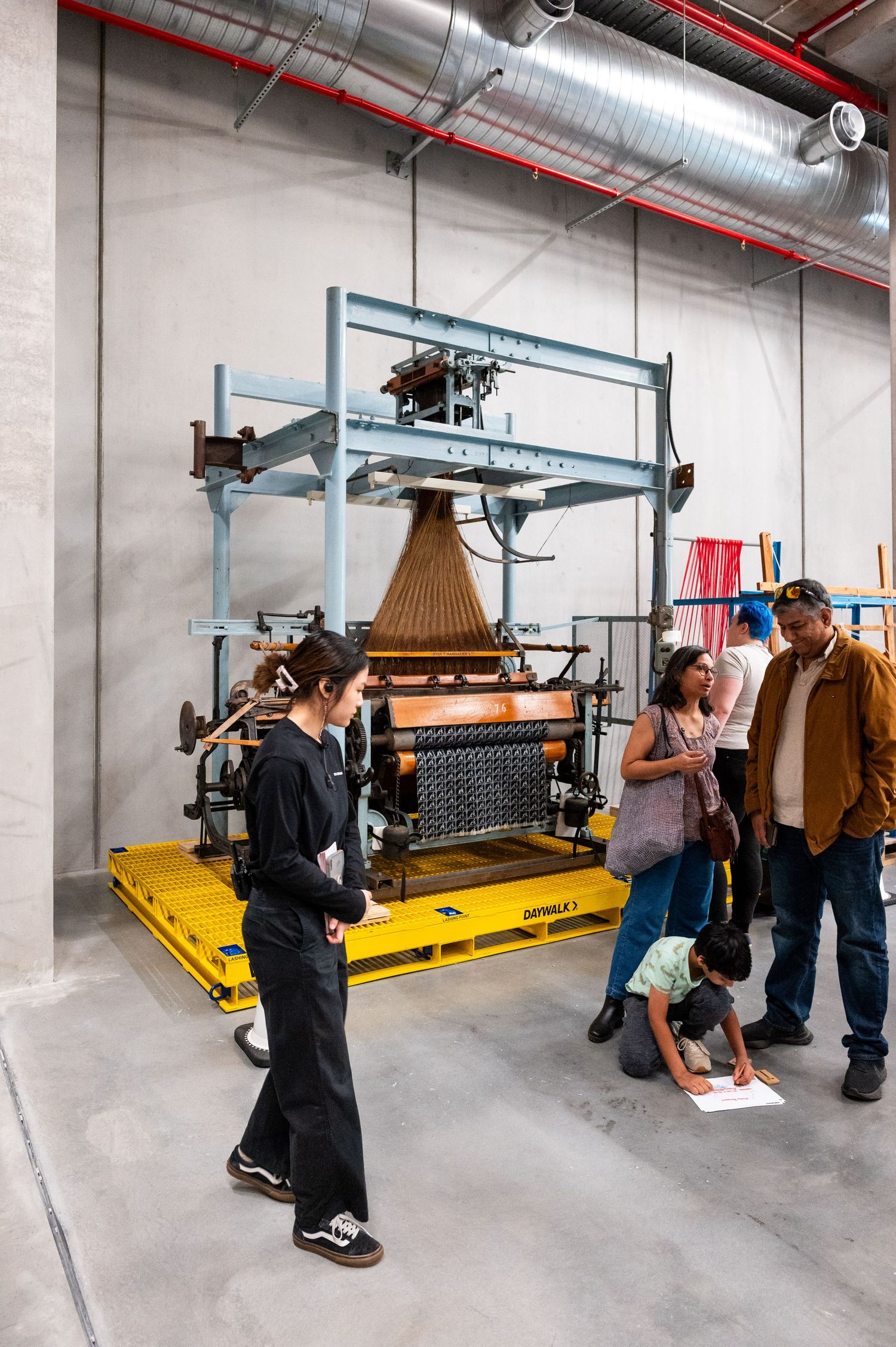 Installation of a large industrial loom or weaving machine in a warehouse space.