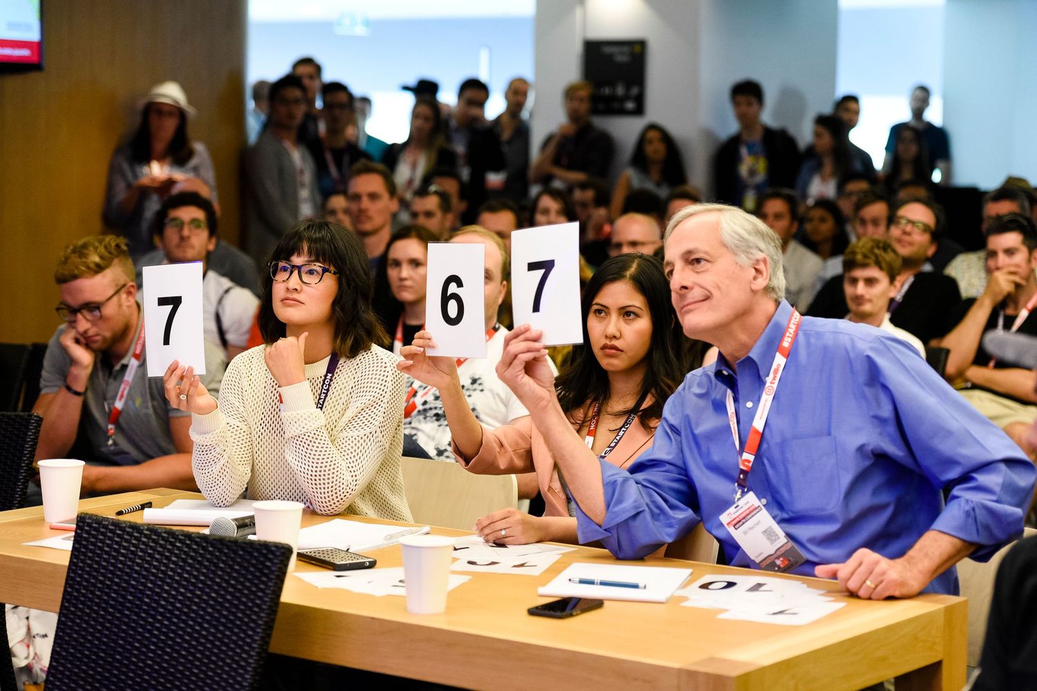 Conference attendees participate in an interactive session in a modern classroom setting.