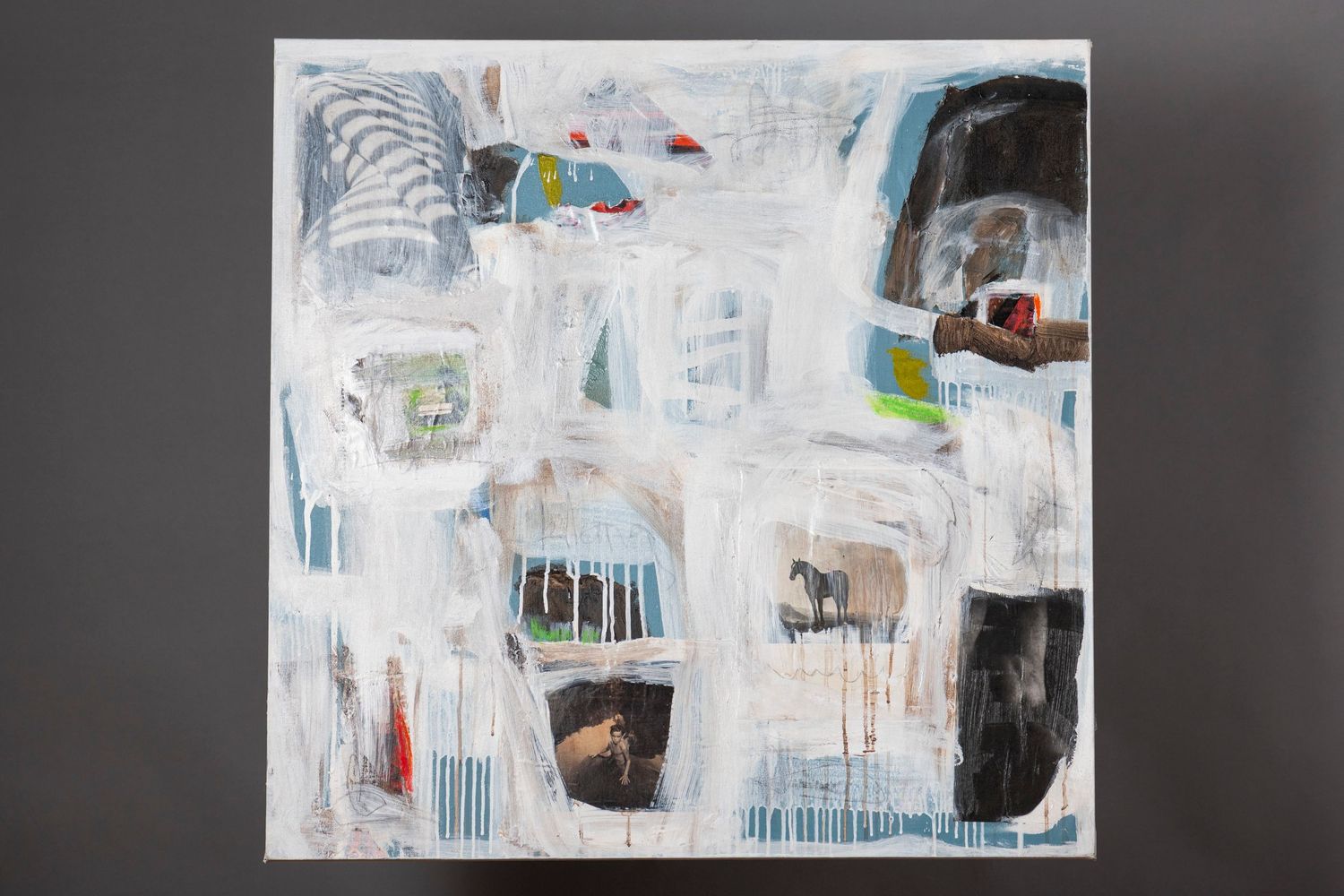 Abstract painting with white, blue and black elements featuring gestural brushstrokes and dripping paint effects on canvas.