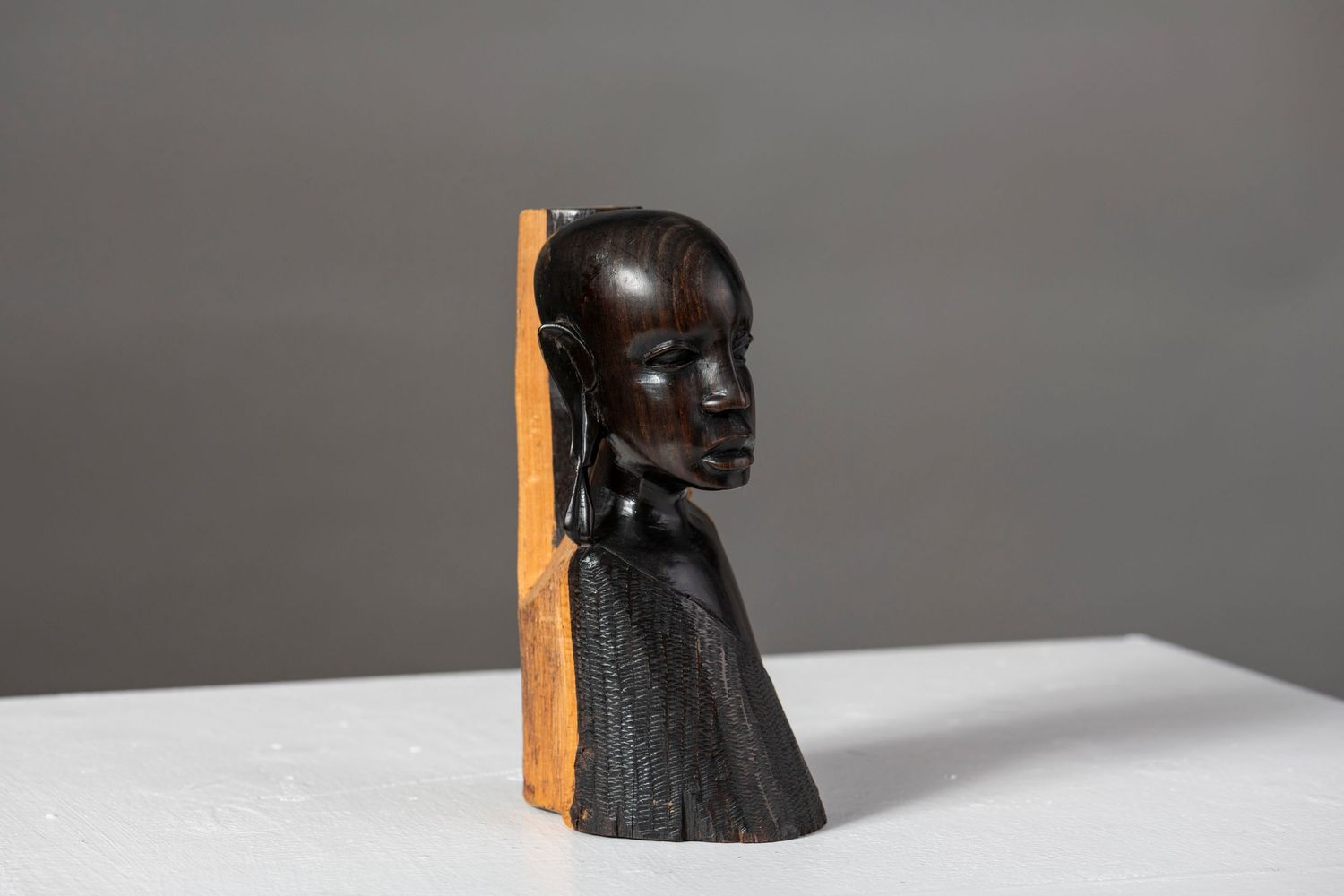 A carved dark wooden horse head sculpture is shown from multiple angles against a gray background.