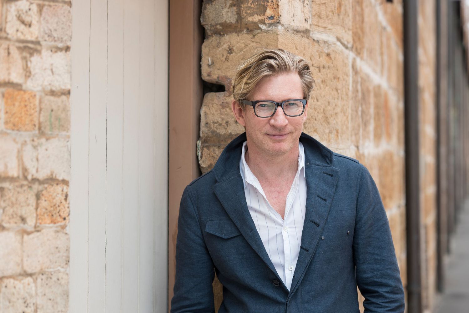 Professional business portraits in front of a rustic brick wall.