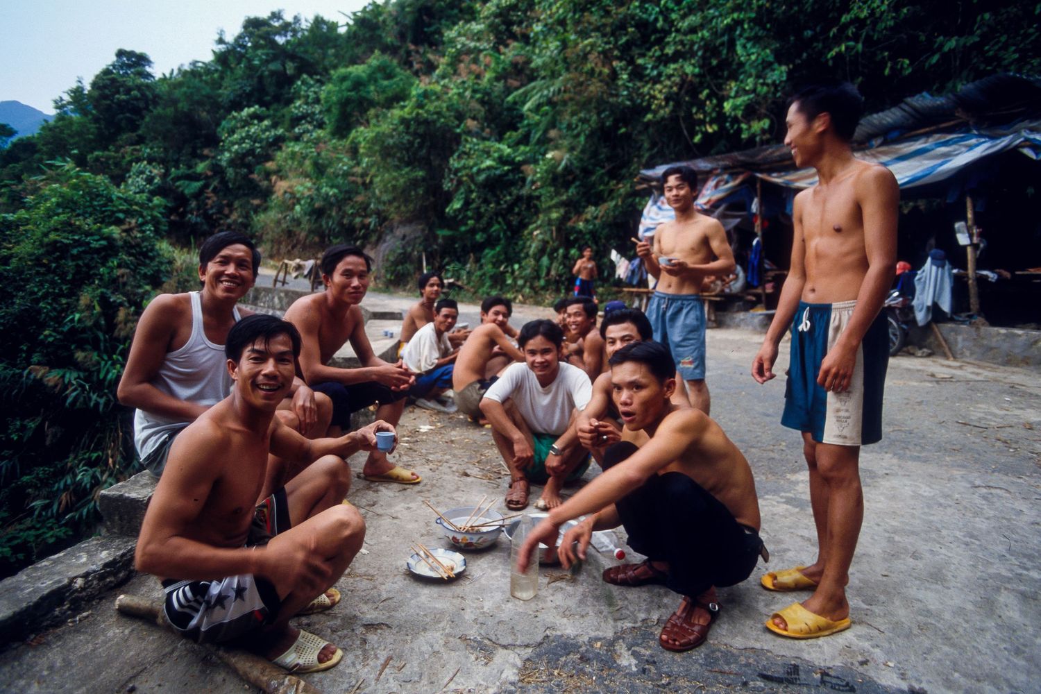 Group gathering for a casual meal outdoors in a natural setting.