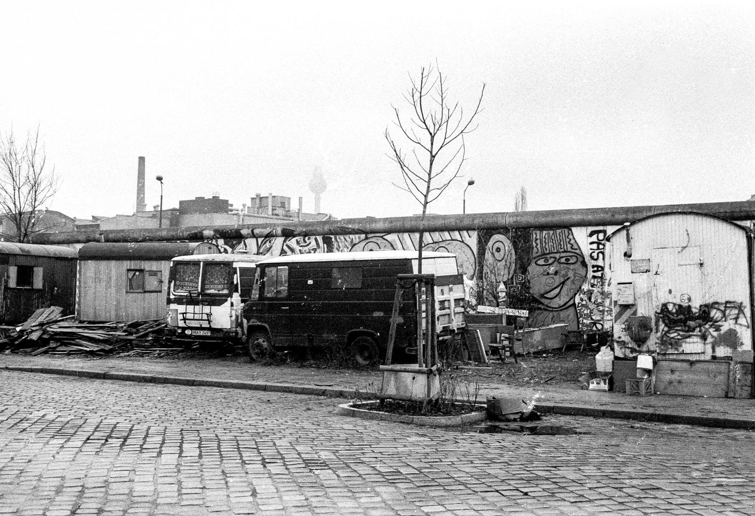 Empty street with guard towers and barriers along the Berlin Wall.