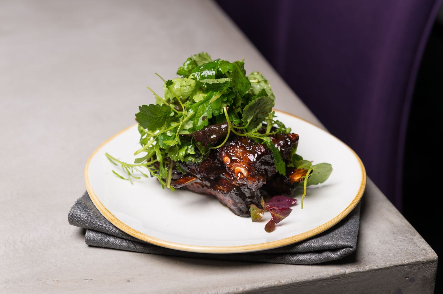 Fresh salad with mixed greens and protein served on white plate.