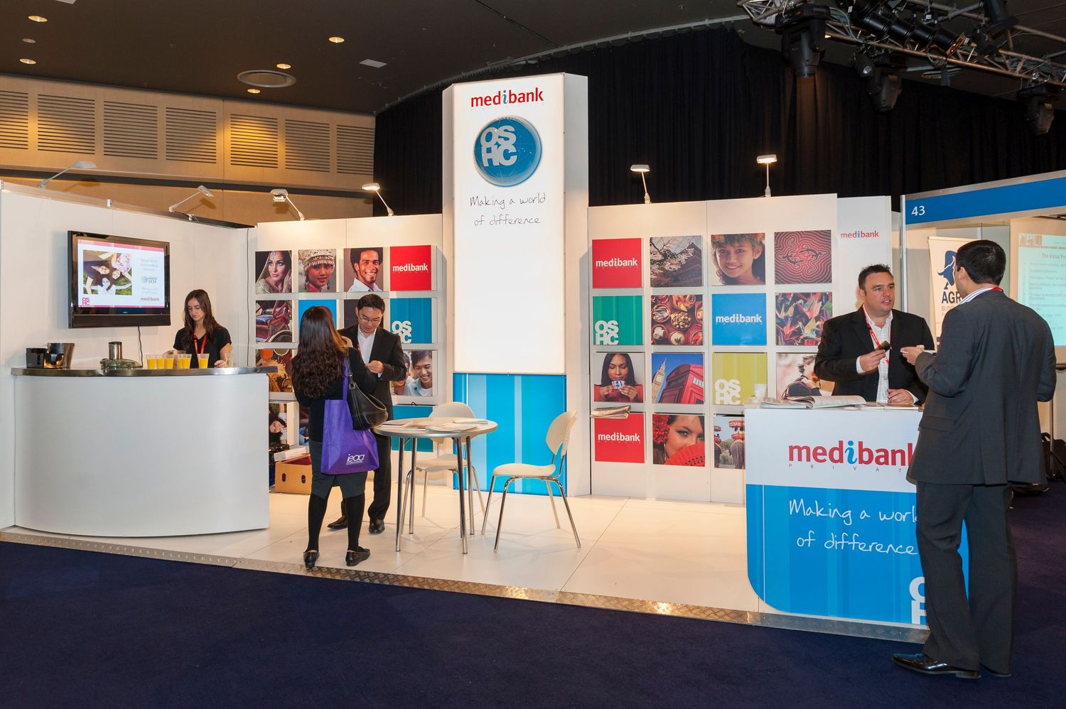 Exhibition hall with modern booth displays and corporate branding elements.