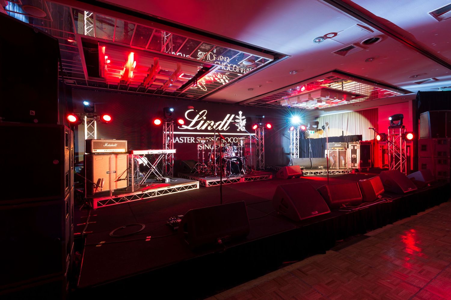 Styled room set up of sponsored event with staging multiple lighting creating a moody atmospheric ambiance.