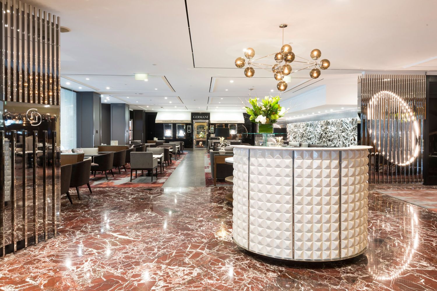 Luxurious dining space featuring gold pendant lights and textured white wall panels.