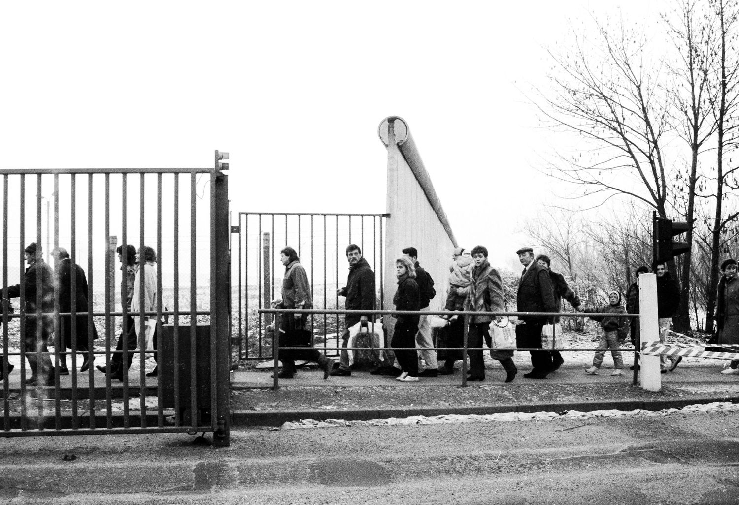 People standing along a viewing platform overlooking the Berlin Wall.