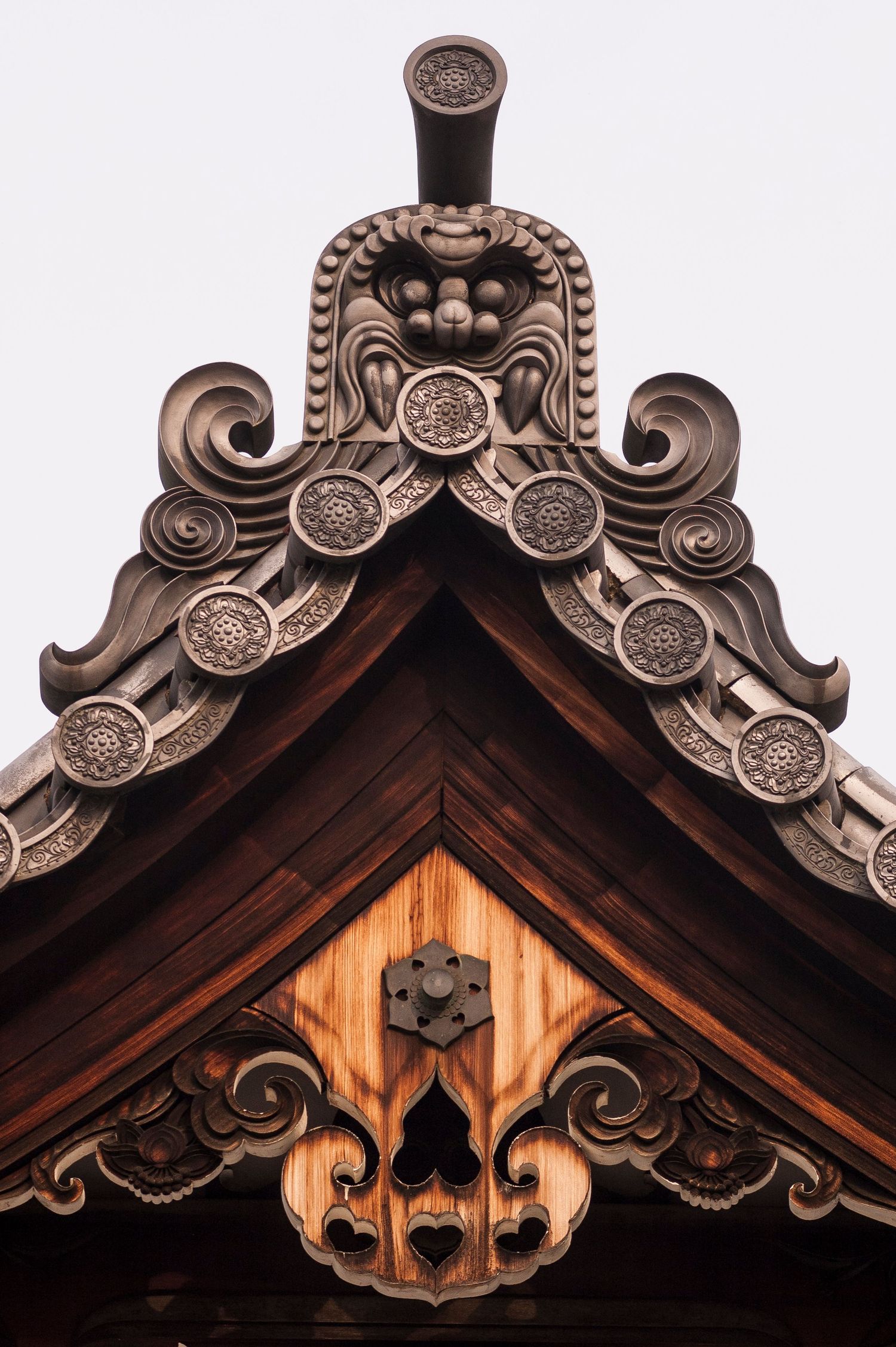 Ornate wooden roof detail of Japanese temple featuring intricate carved designs and scrollwork patterns.