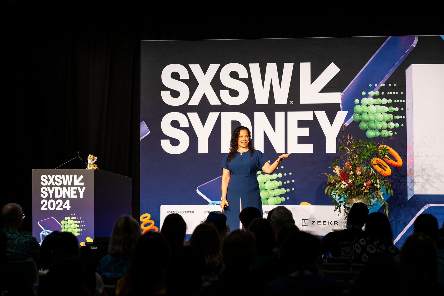 Conference stage setup with SXSW Sydney branding and lighting effects.