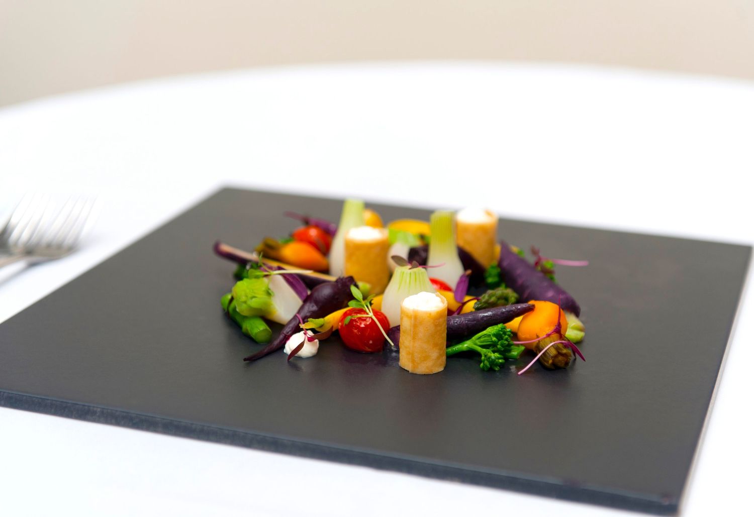 Colorful candies and decorative elements arranged artistically on a dark slate surface.