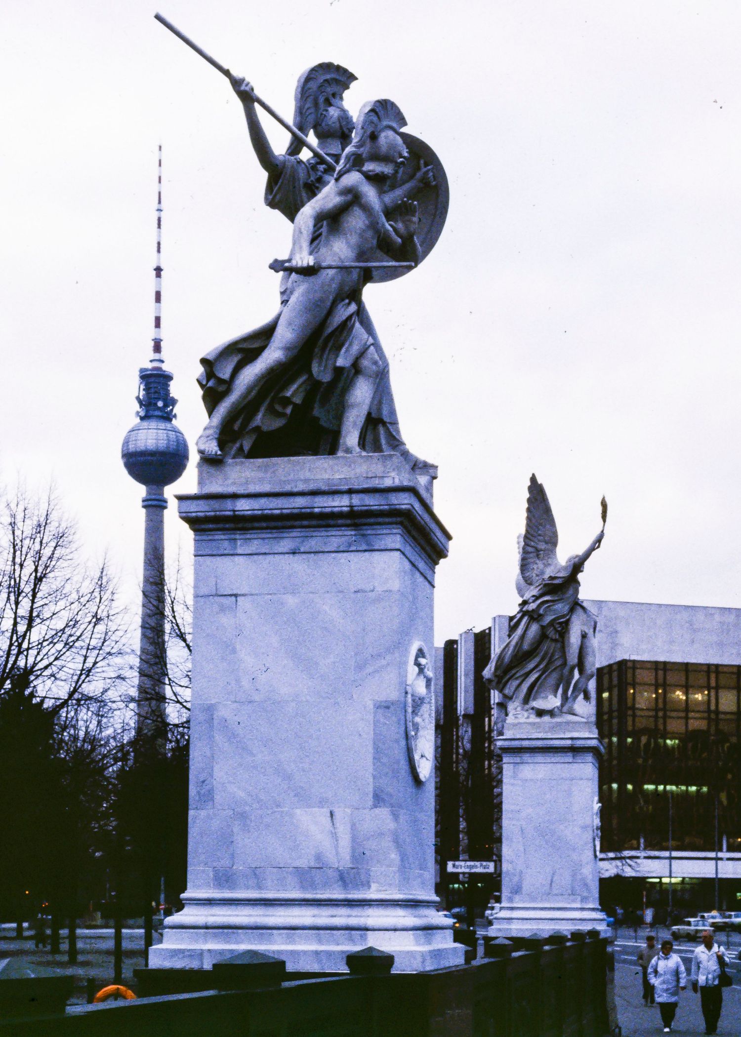 Classical statues and monuments with the Berlin TV Tower visible in the background.