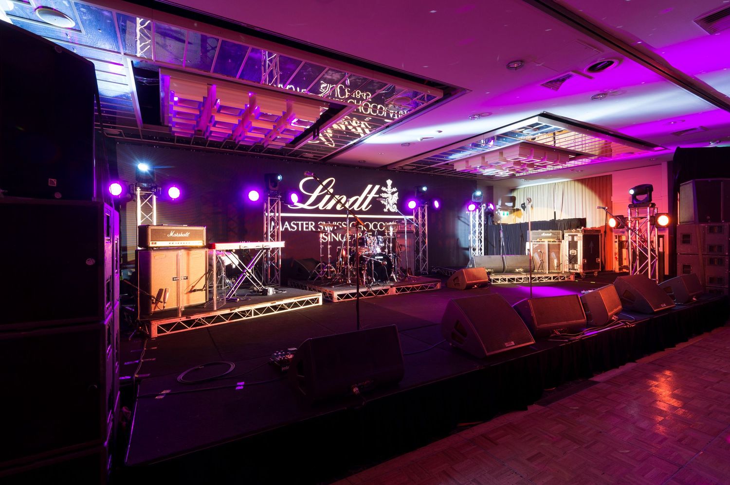 A nightclub interior illuminated with purple and pink lighting creating a vibrant atmospheric ambiance.