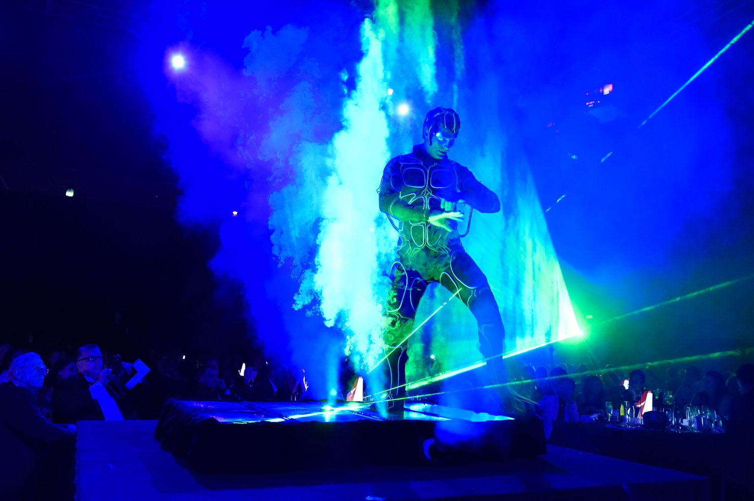 Dramatic blue stage lighting effects create atmosphere at corporate event.